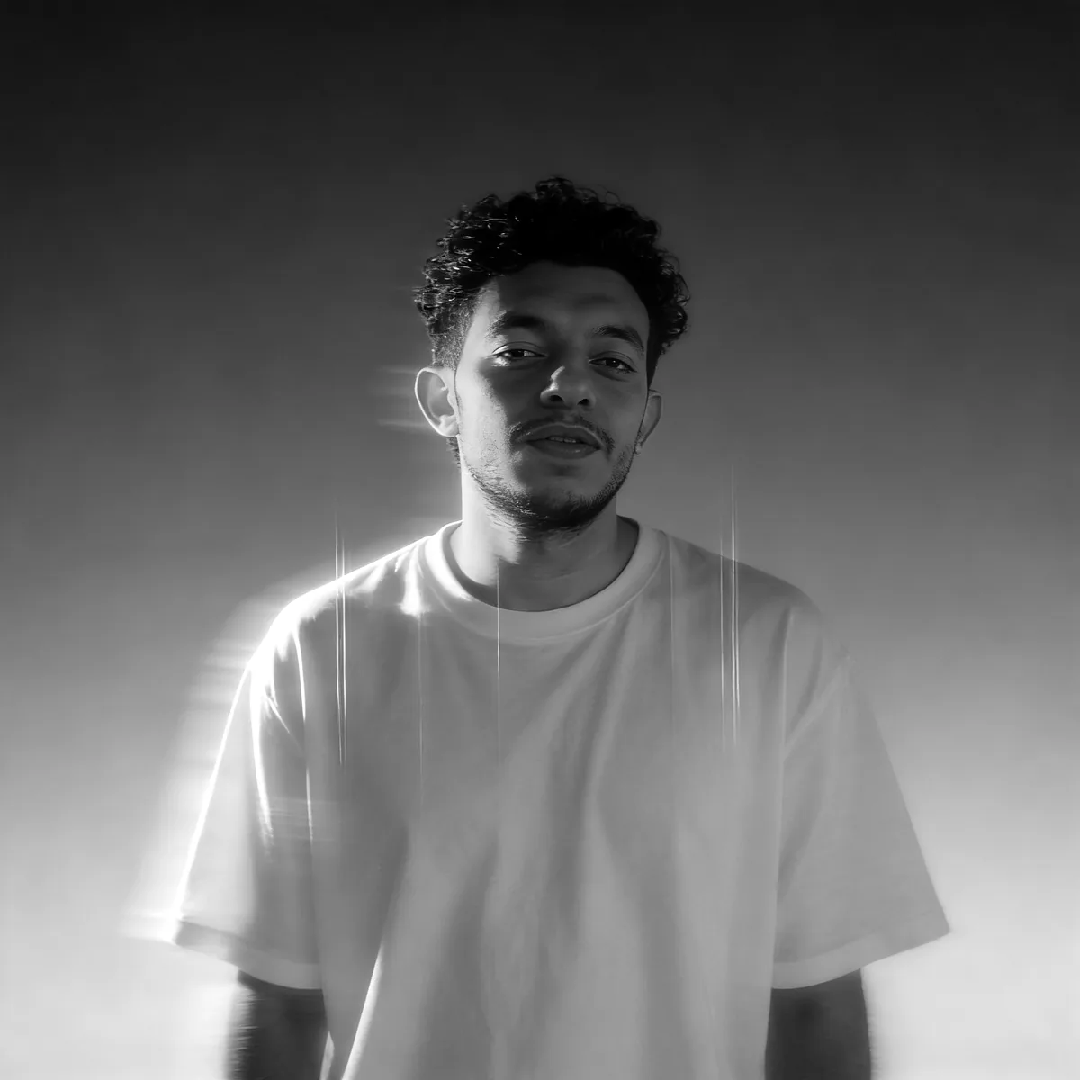Black and white portrait of Wael Fikri in a white T-shirt