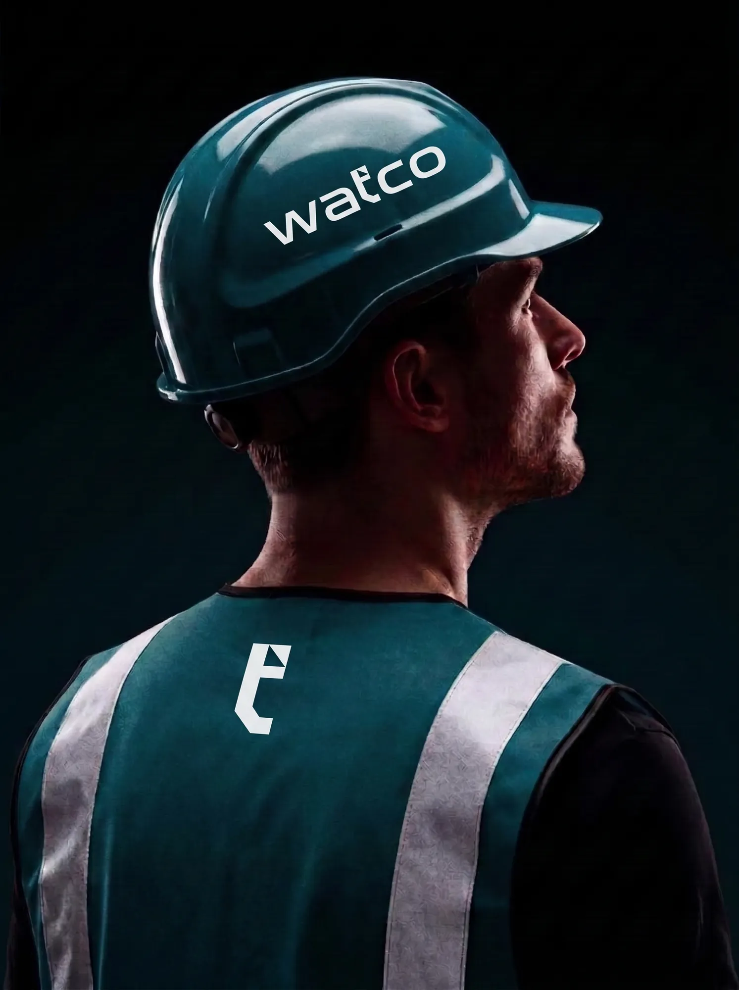 Worker in a teal Watco hard hat and safety vest with the t icon on the back